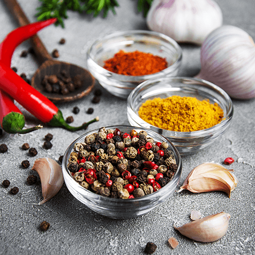 3 Schälchen mit Gewürzen, Pfefferkörner, Curry und Paprikapulver